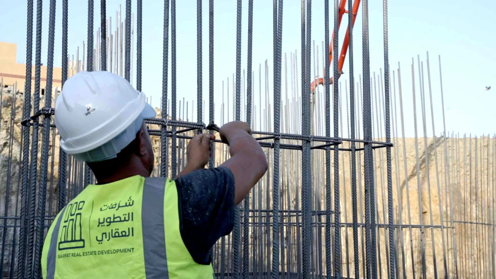A worker fixing the reinforcement cage of a concrete column on a Shurfat site